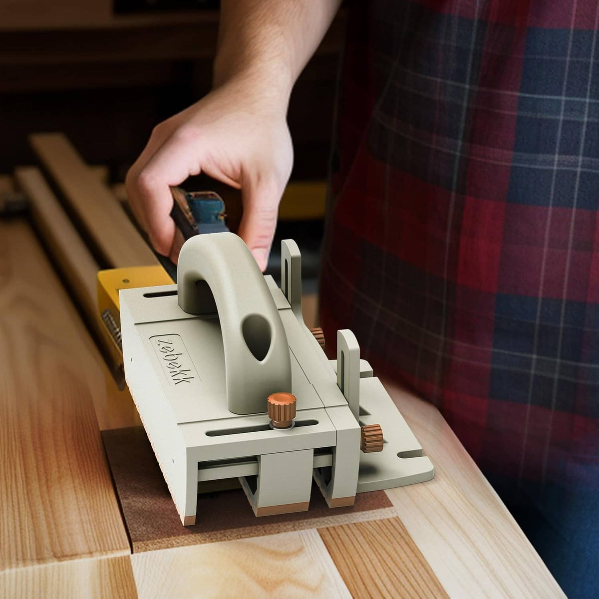 Push block on a table saw, cream body with brown non-slip pads held by hand