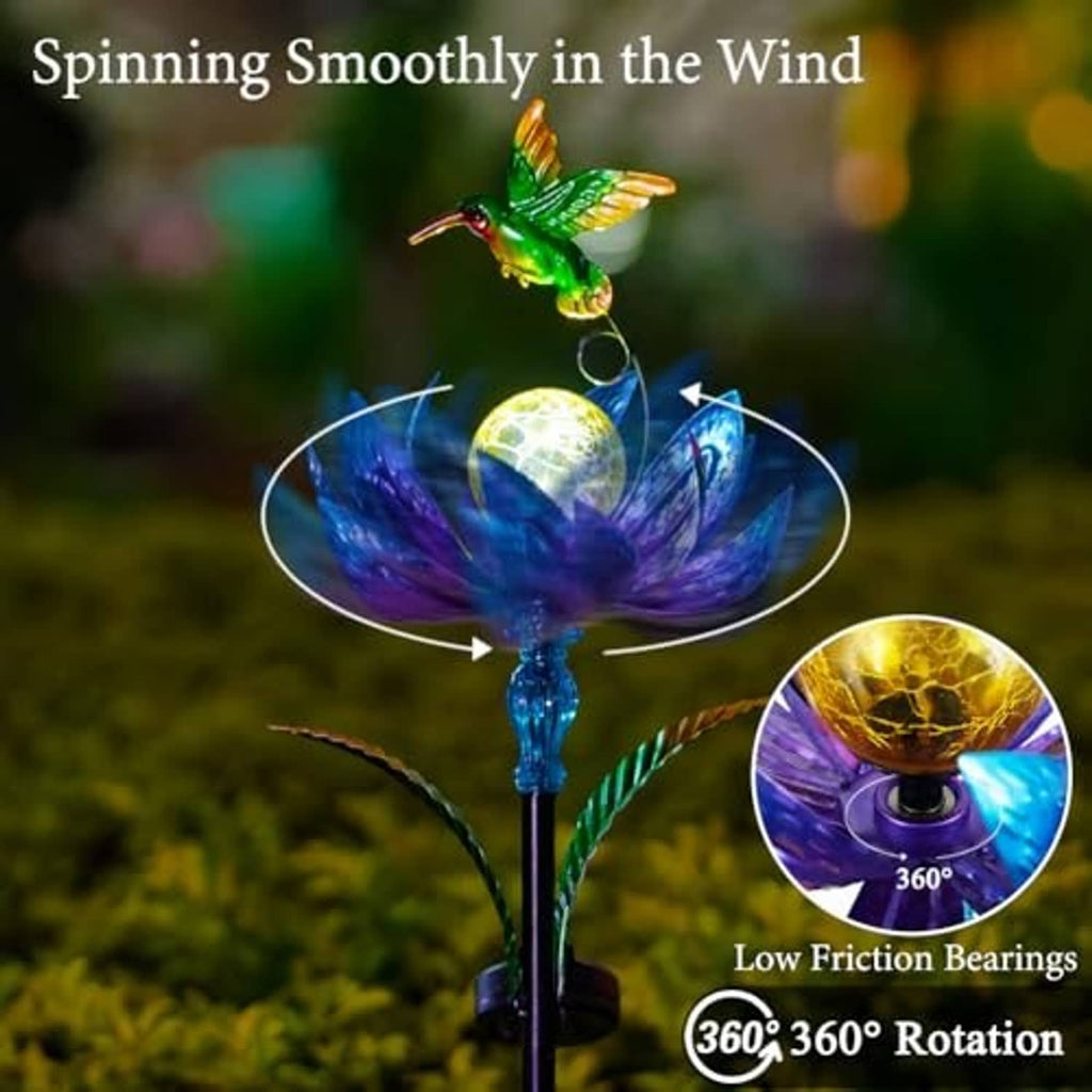 Solar wind spinner with green hummingbird above glowing yellow LED orb and blue flower