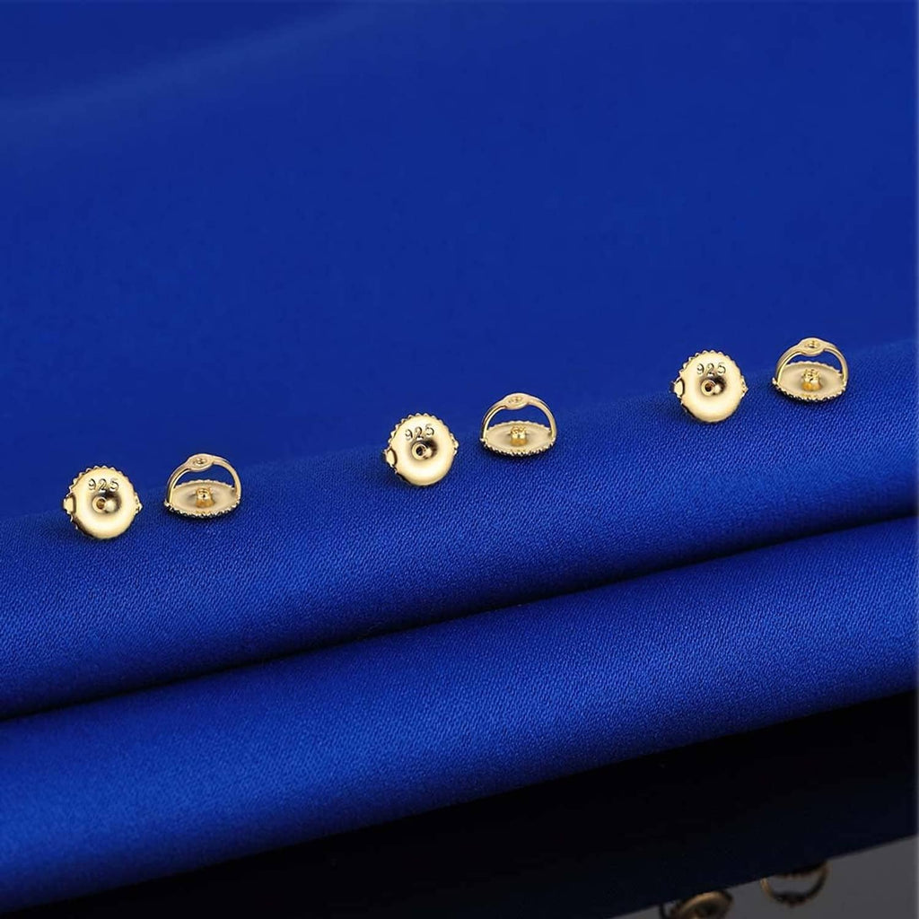 Assorted gold-tone screw earring backs and posts with 925 stamps on blue cloth