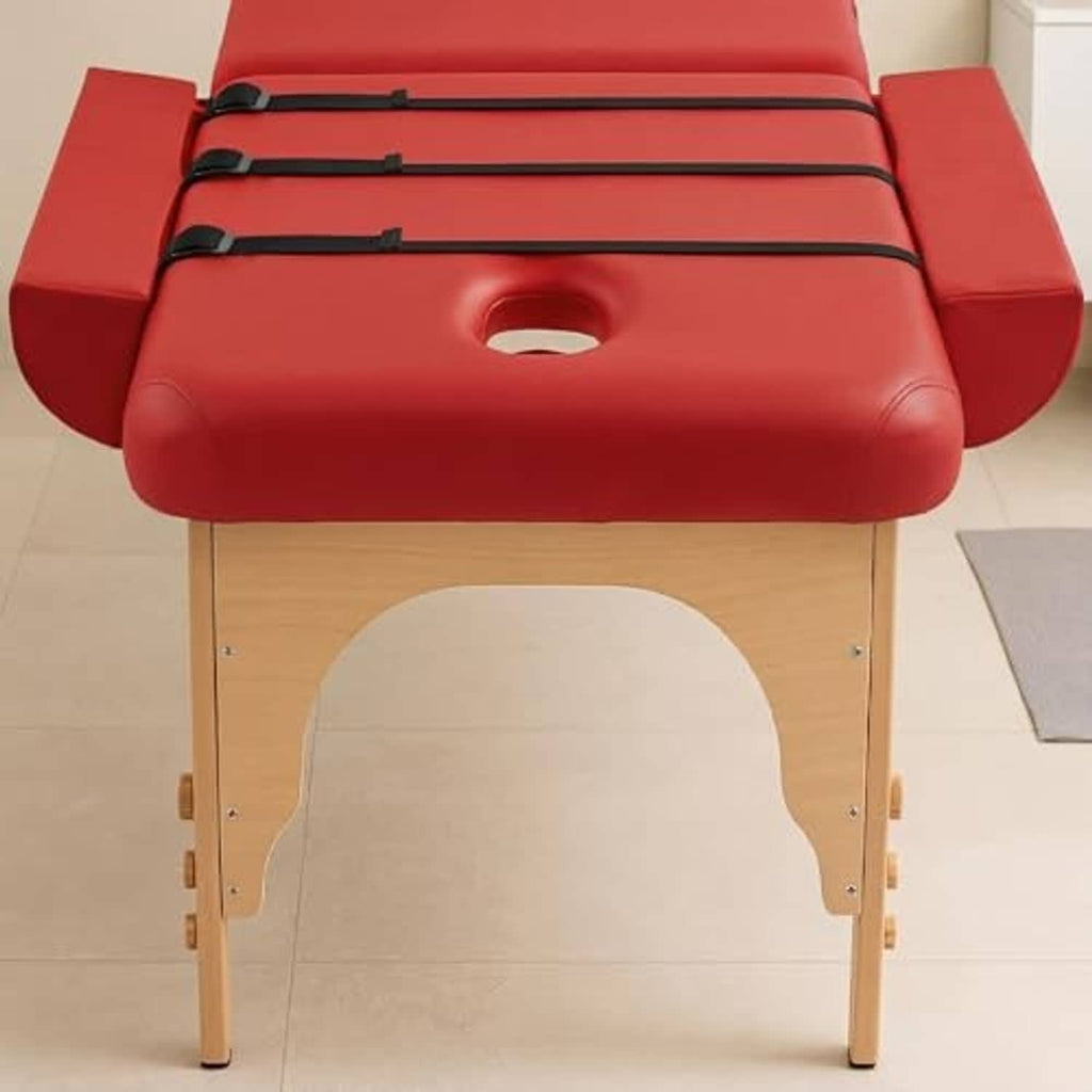 Close-up of red massage table arm rest bolsters with black bands and center cutout