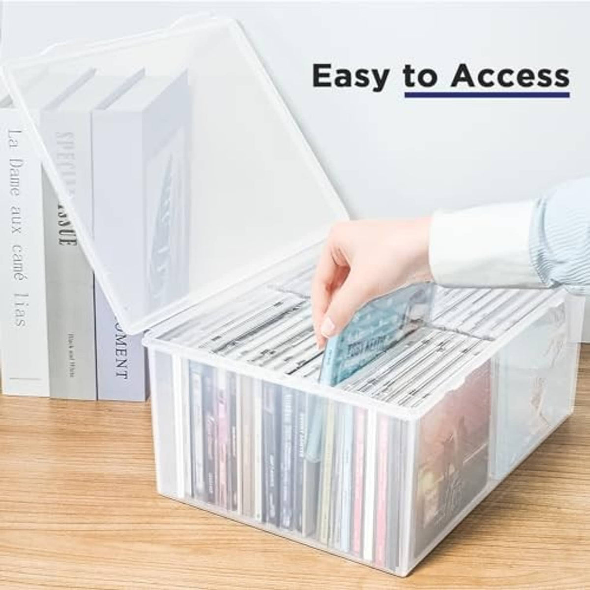 Clear CD storage box with hinged lid; hand lifts CD sleeves inside