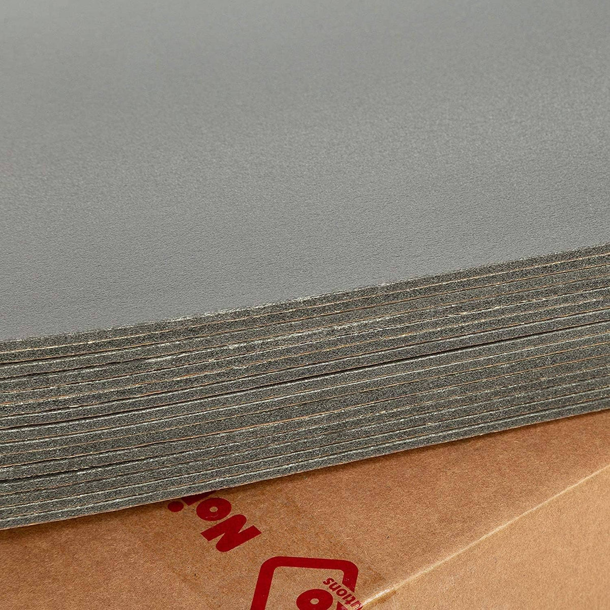 Dark gray insulation liner with thin textured brown adhesive strip along the edge