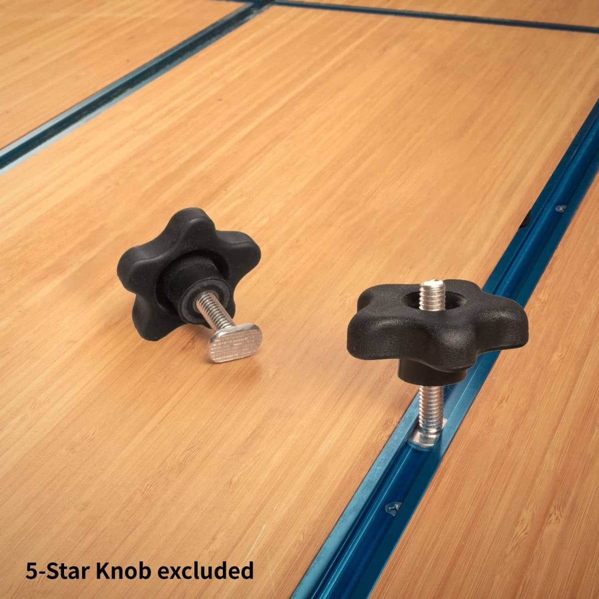 Silver T-track bolts with black star knob mounts on blue rail over wood