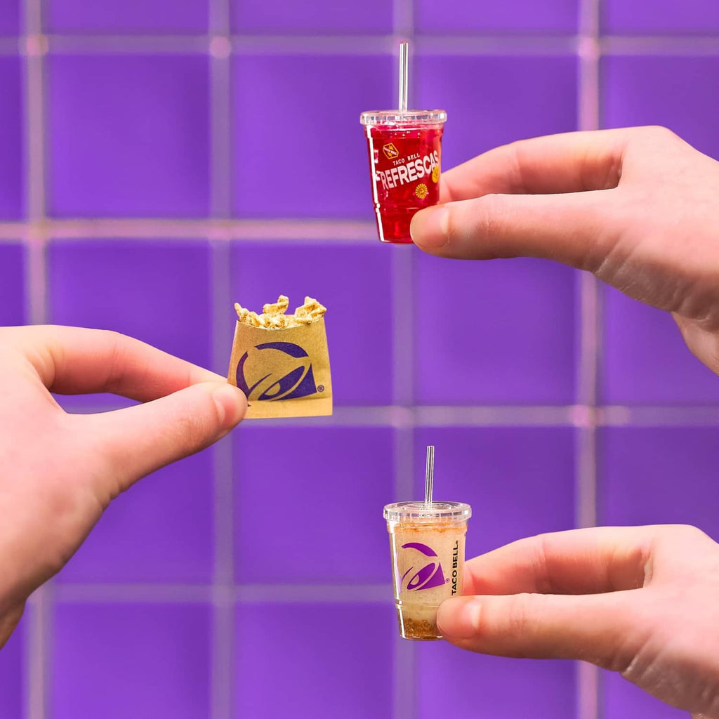 Mini Taco Bell mini drinks and snack pack held by hands