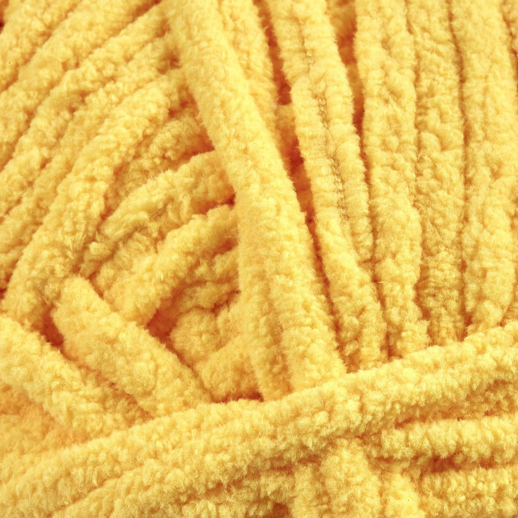 Close-up of yellow chenille yarn texture with thick, soft pile strands