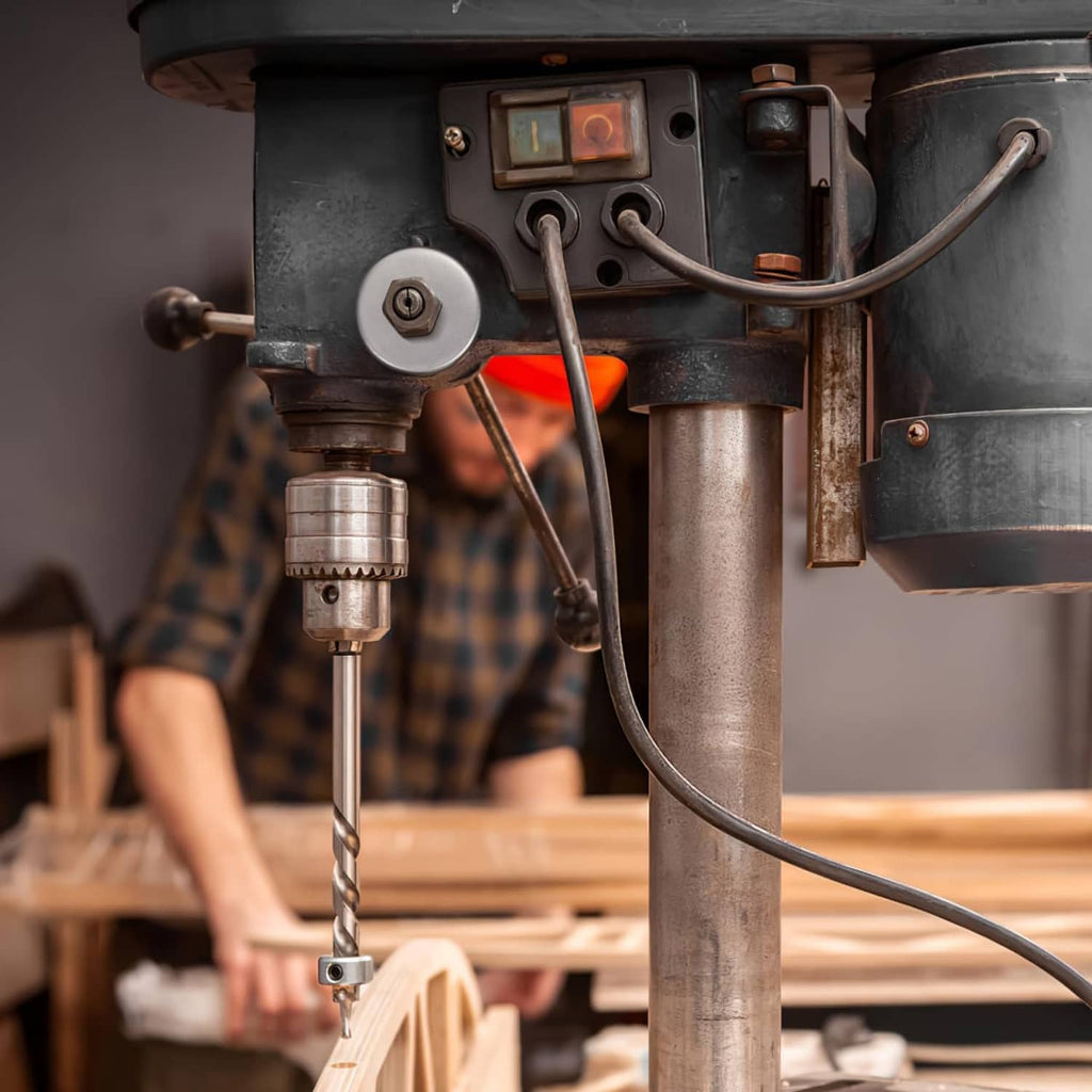 Drill press return spring assembly mounted near the spindle support