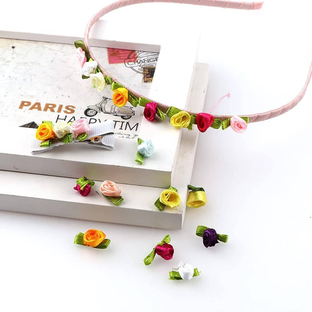 Fabric rose sprigs with green ribbon leaves attached to a curved decorative band
