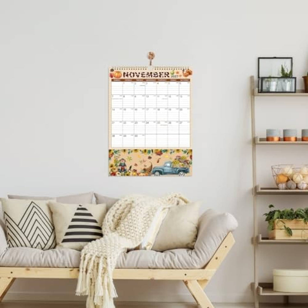 2027 wall calendar with pocket hanging on wall above sofa in living room