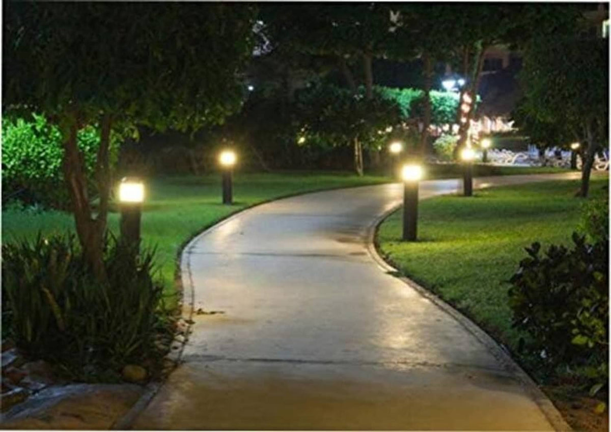 Outdoor driveway path lights casting bright cool-white illumination on the road.