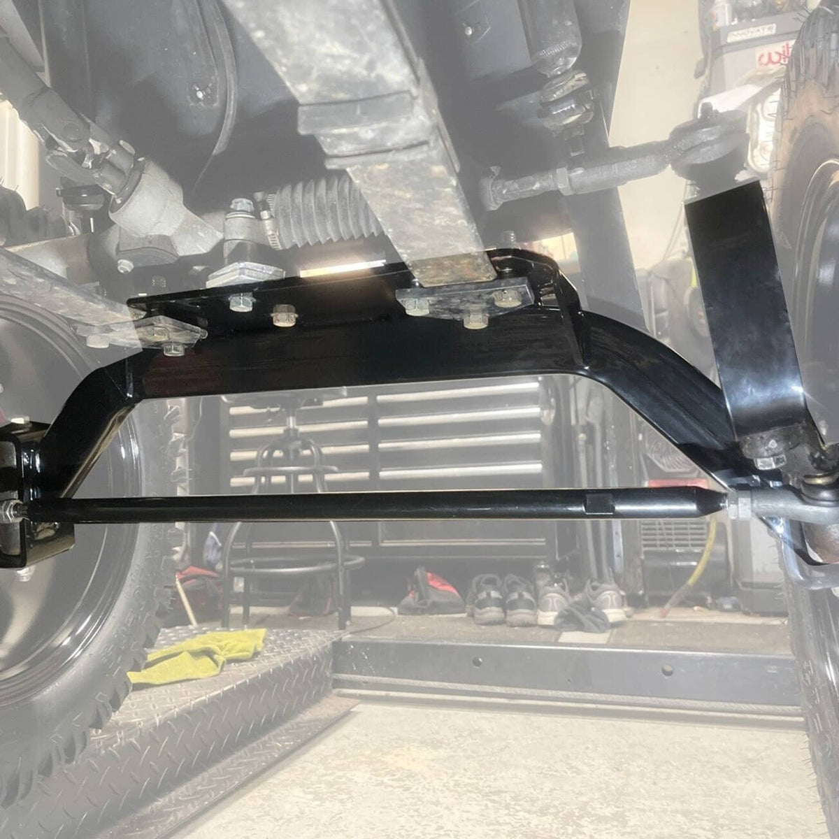 Under vehicle view showing installed lift kit hardware near front axle