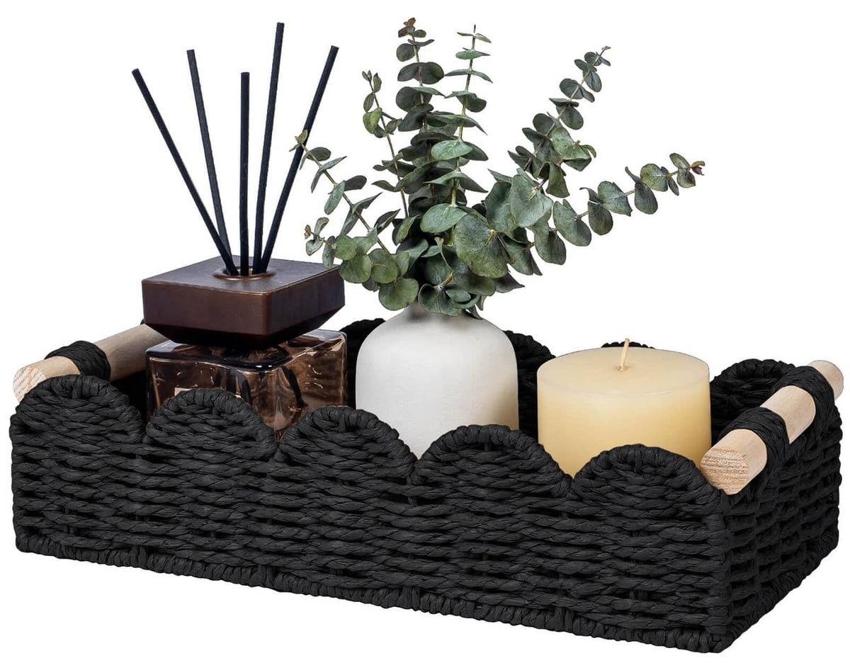 Black woven toilet paper storage basket with wood-capped handles and assorted bathroom items