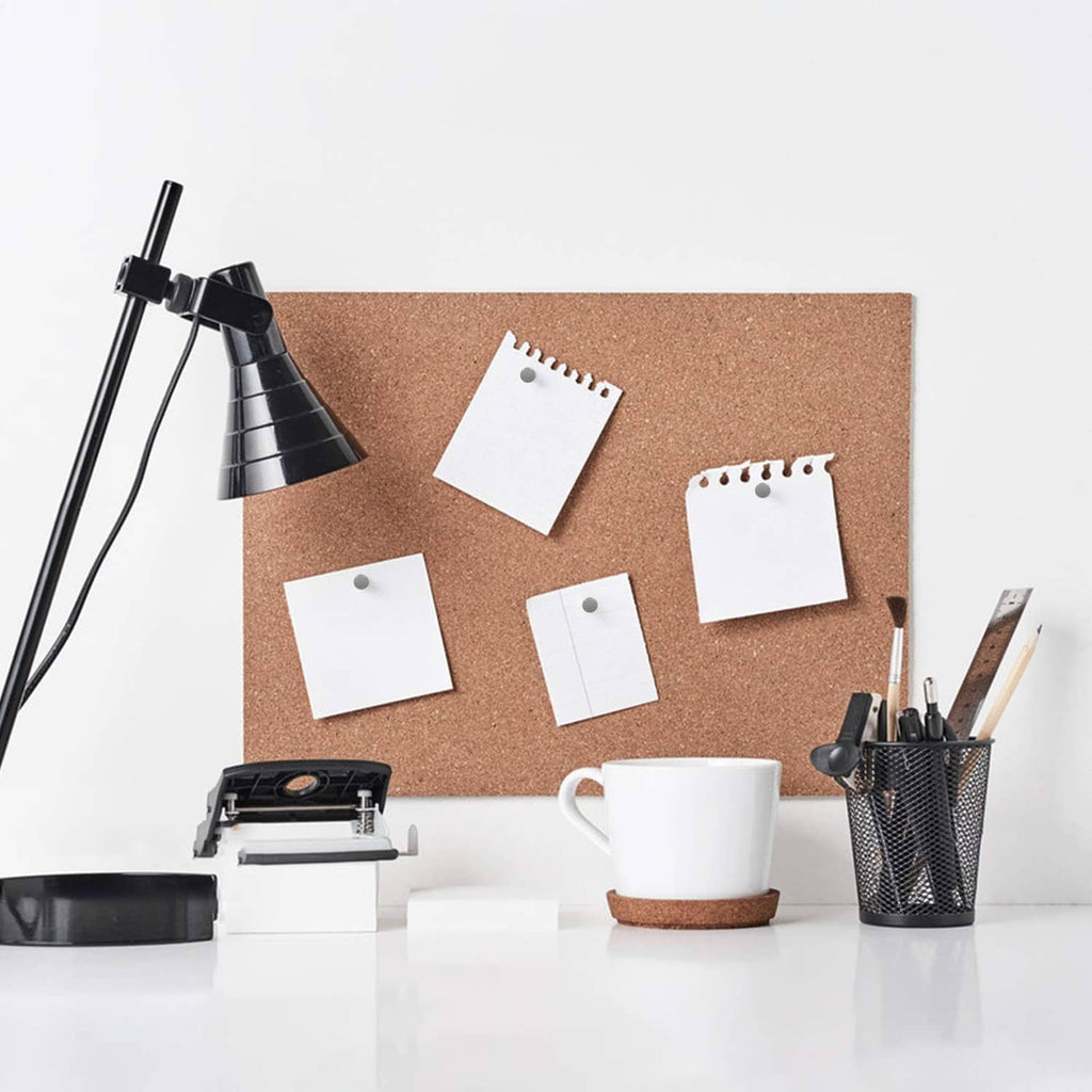 Thumbtacks holding square notes on a corkboard, gray heads with gold pins