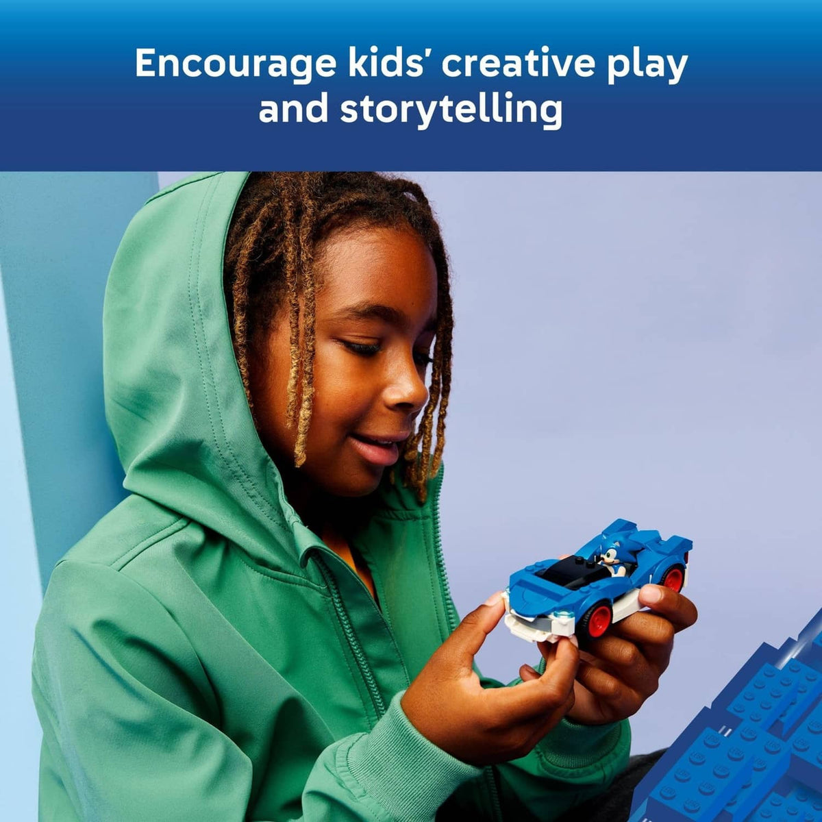 Child holding a blue LEGO Sonic race car toy with Sonic minifigure