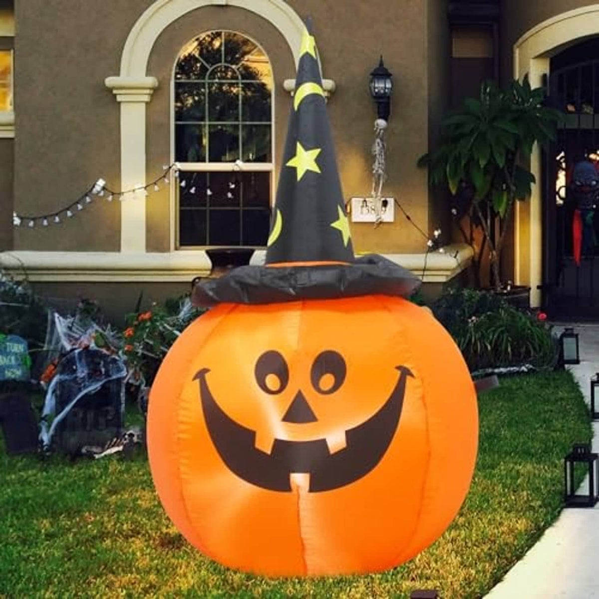 Inflatable orange pumpkin with jack-o'-lantern face and black witch hat