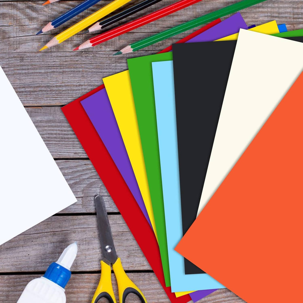 Yellow cardstock among assorted colored sheets, fanned with white and black