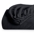 Black plush fitted fleece sheet corner with elastic seam and soft textured fabric