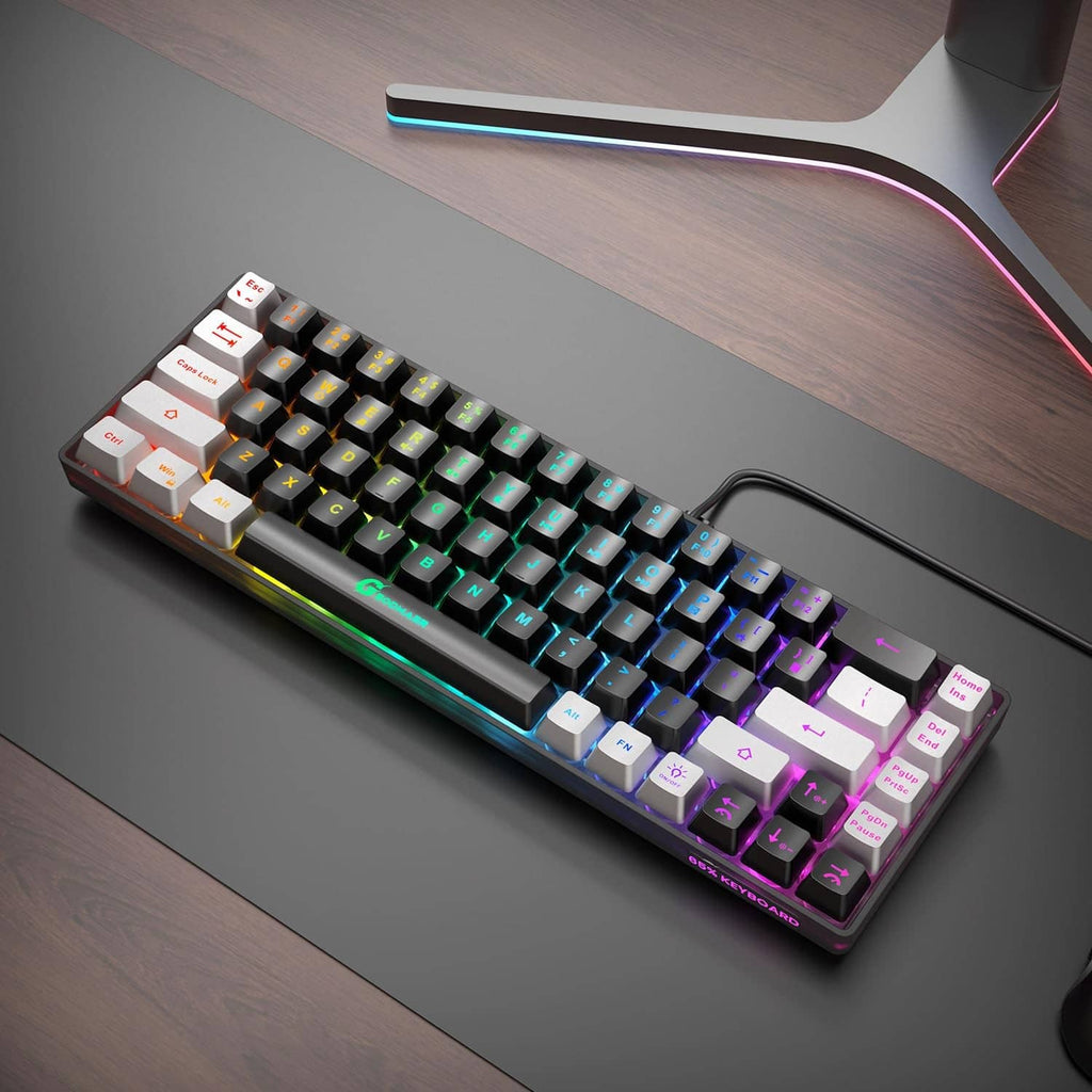 Compact wired RGB gaming keyboard on desk, black and gray keys with multicolor glow.