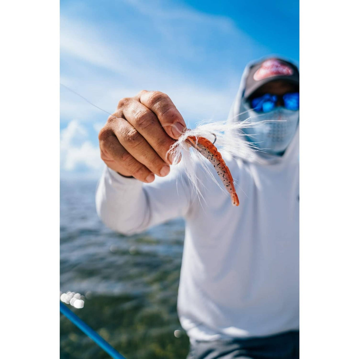 Angler holding a shrimp-shaped soft bait on a hook