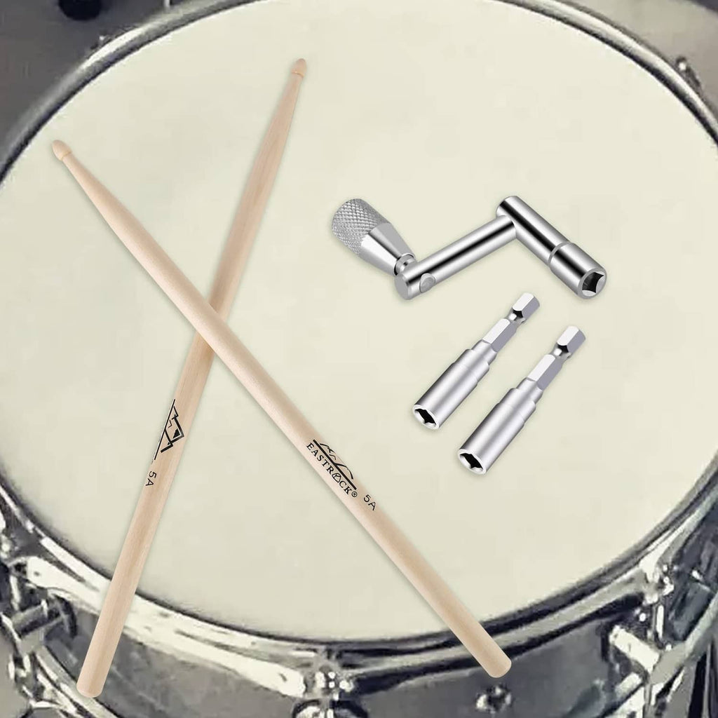 Drum tuning key and drill bits laid on drum head, silver metal set