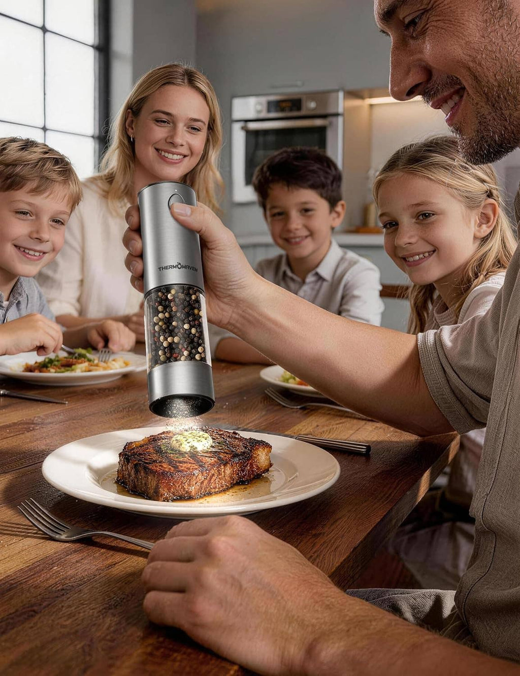 Stainless THERMOMAVEN electric salt and pepper grinder dispensing over steak at the dining table
