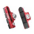 Red C-caliper brake pad adapters pair with black rubber pads and mounting bolts