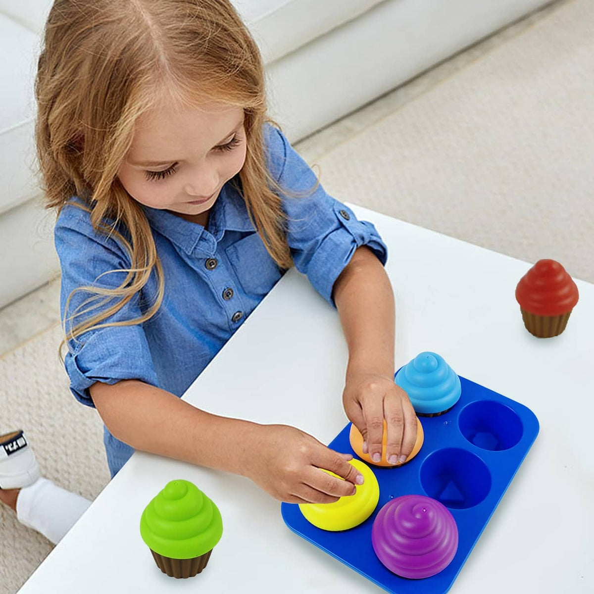 Child playing with blue cupcake tray and colorful stackable pieces