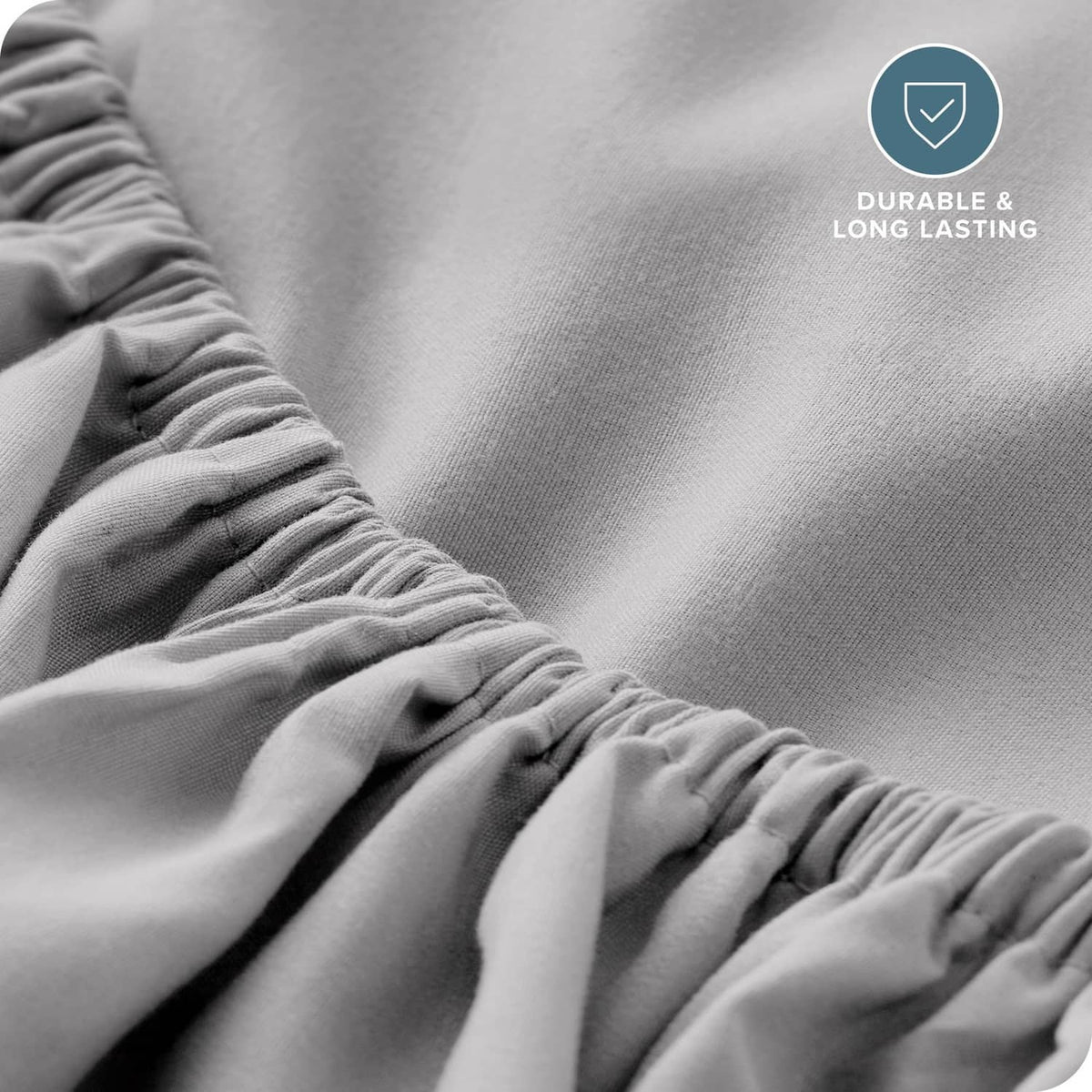 Light grey fitted sheet fabric close-up showing smooth knit weave