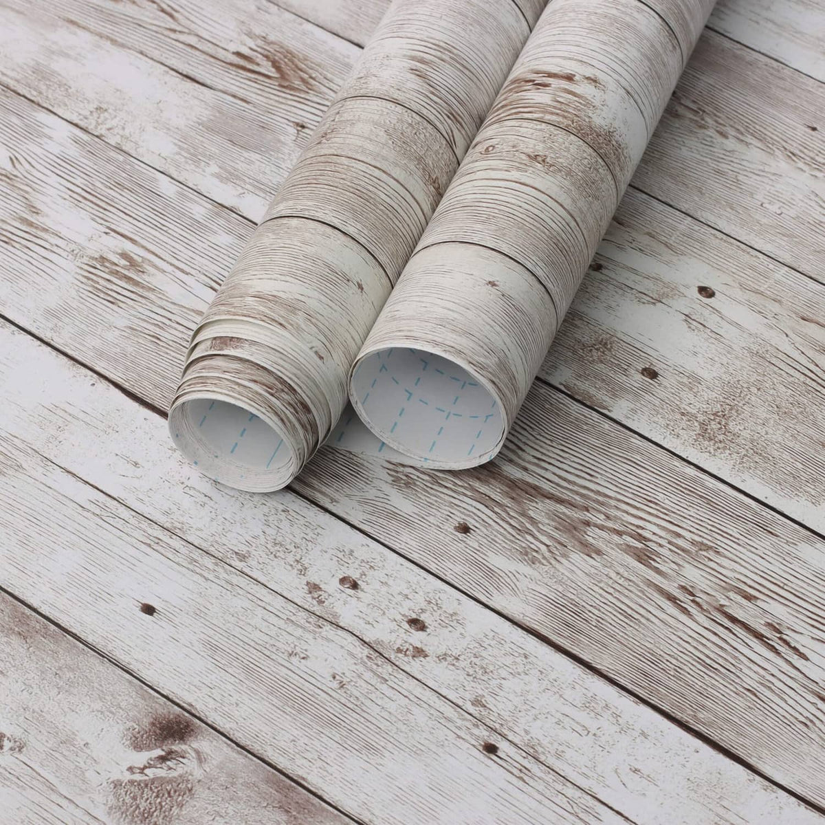 Light wood grain wallpaper rolls with whitewashed plank pattern.
