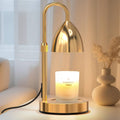Gold candle warmer lamp with arched handle and reflective metal shade on round base stand