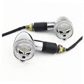 Pair of chrome skull turn signal lights with clear round lenses and black wire stems