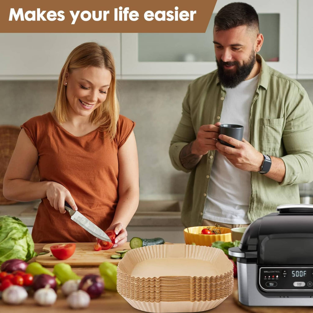 Stack of air fryer paper liners beside air fryer while preparing food