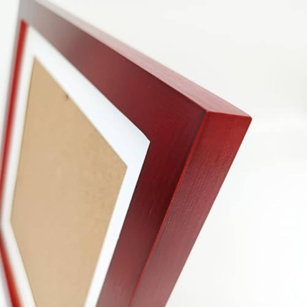 Side profile of red solid wood picture frame with white mat edging