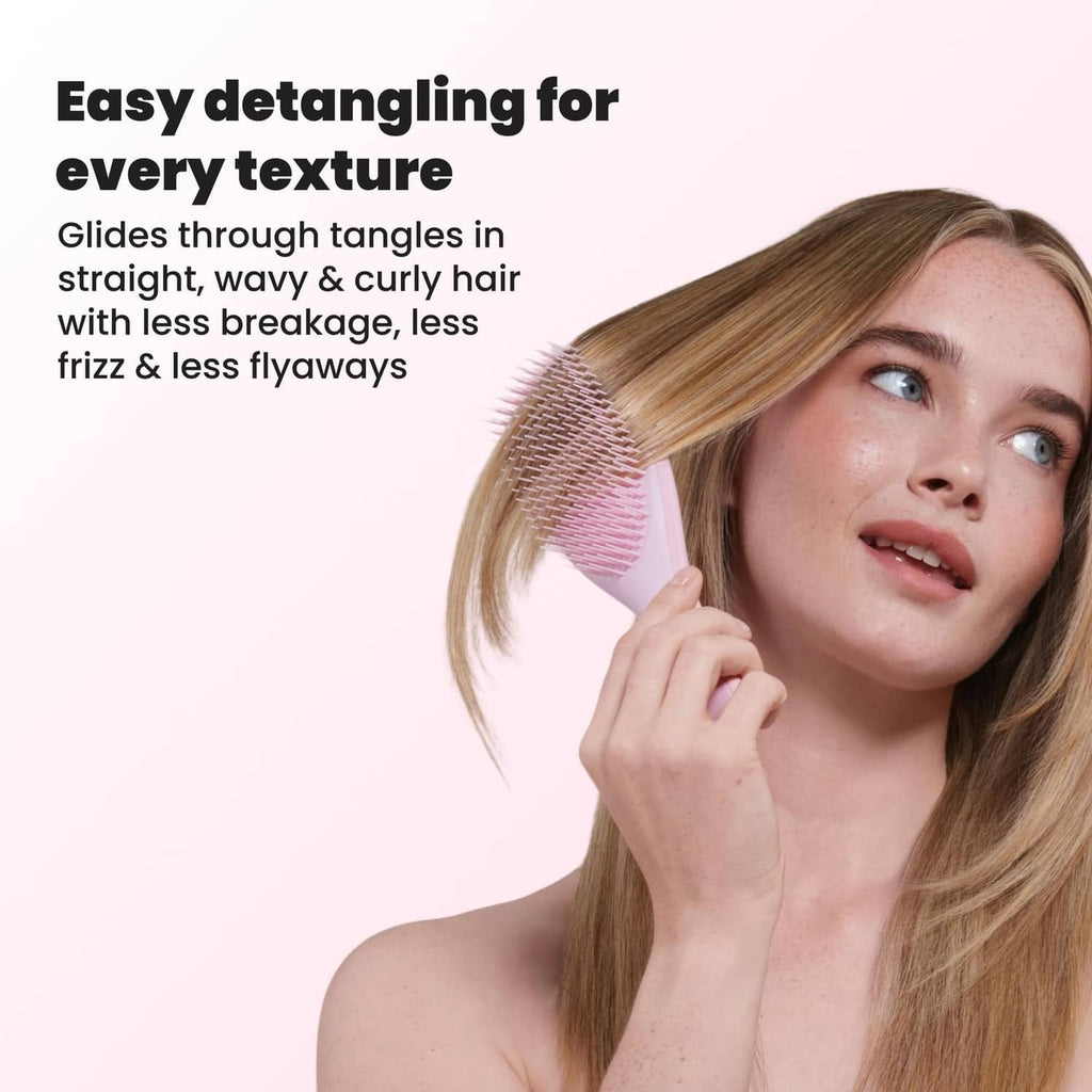 Pink detangling hairbrush held next to long hair for everyday textures