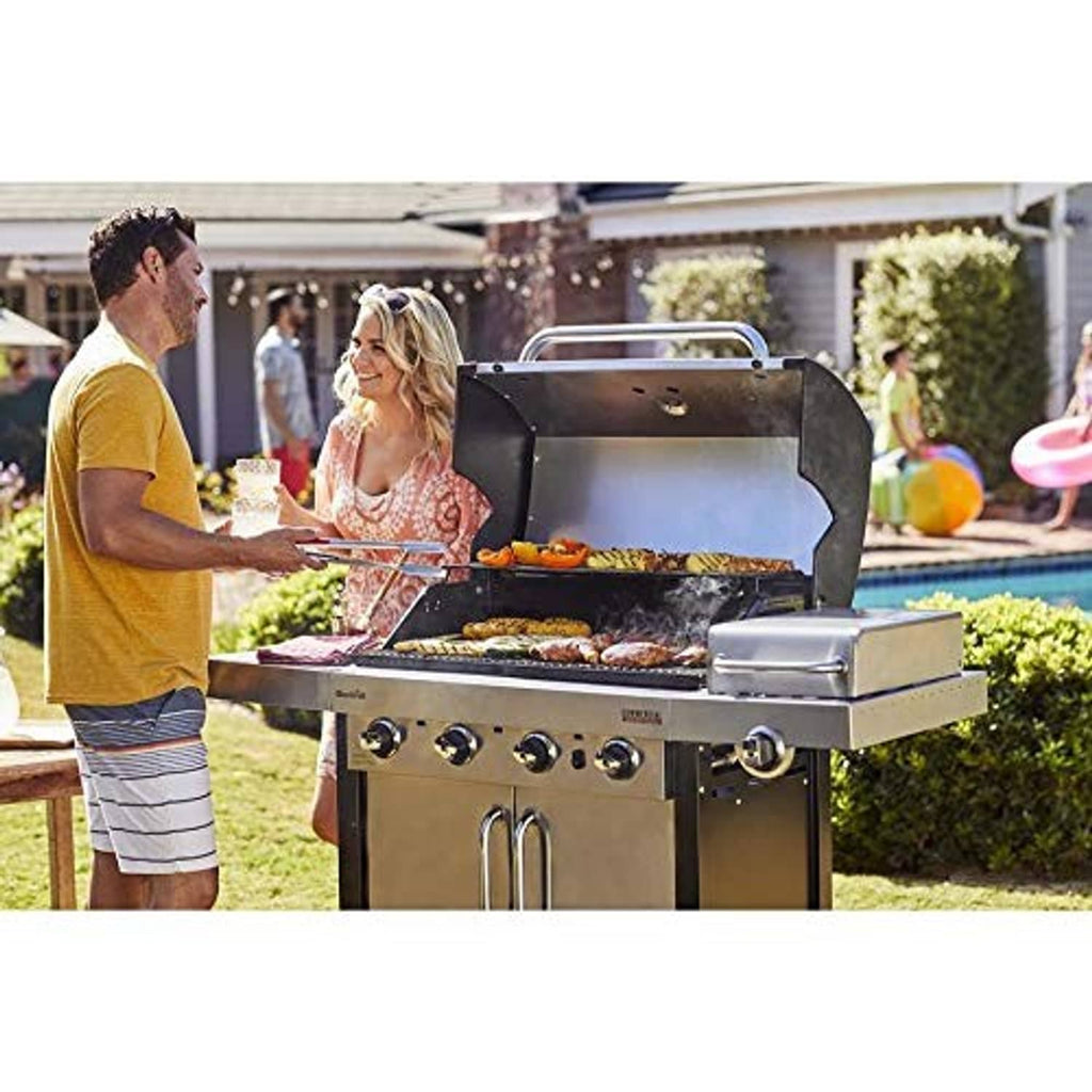 Outdoor gas grill with open hood at backyard gathering