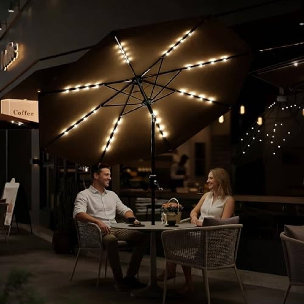 Tan outdoor umbrella with solar LED lights overhead above a patio dining table
