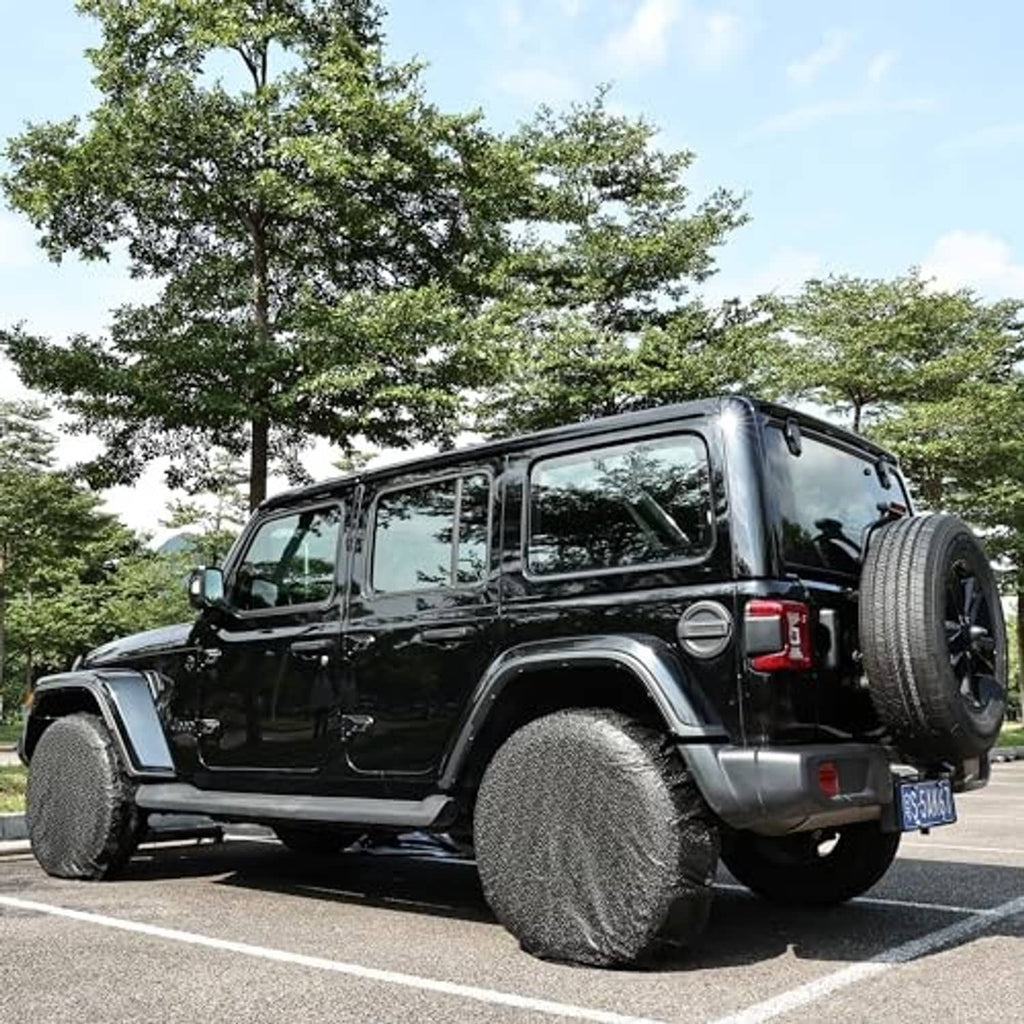 Black RV wheel tire cover fitted over spare tire on a dark off-road vehicle