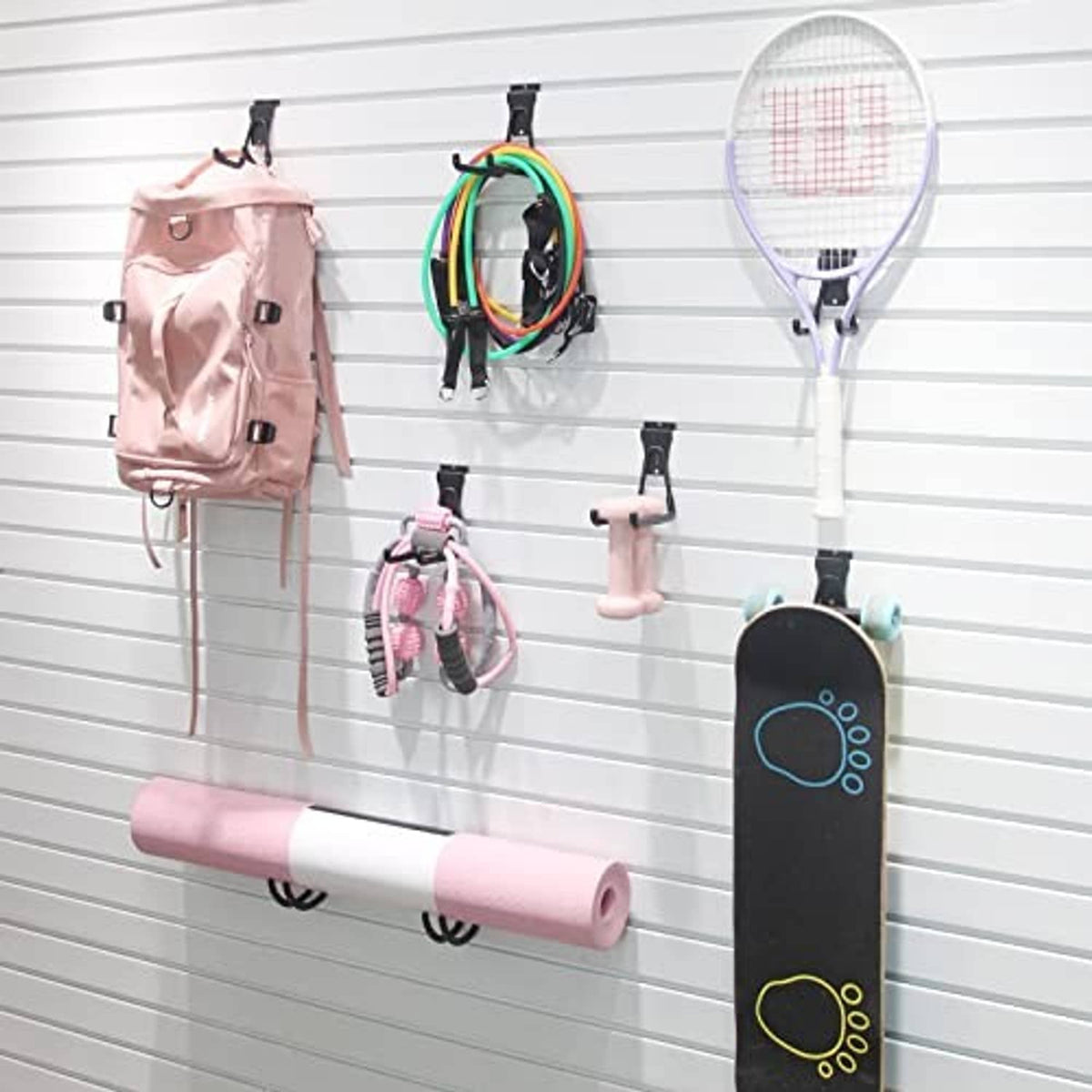 Black slatwall hooks holding garage tools and accessories on slatwall