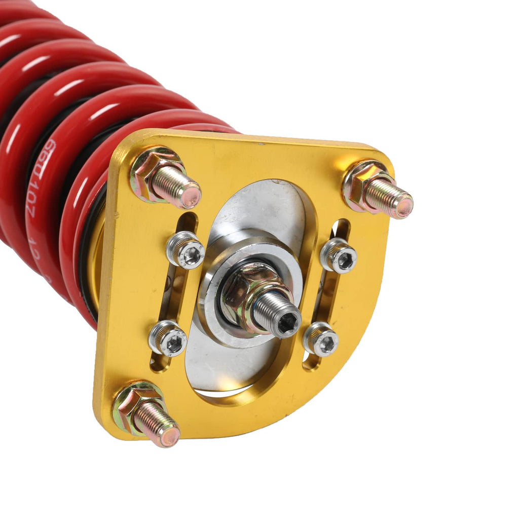 Close-up of gold upper mount plate on coilover strut with red spring