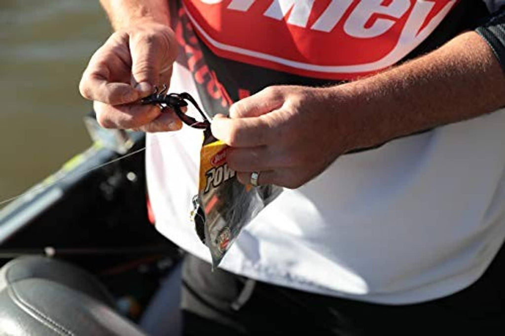 Fisherman hands holding a lime green craw lure near a boat