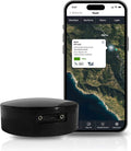 Black magnetic GPS tracker puck with USB ports, paired with smartphone showing a map.