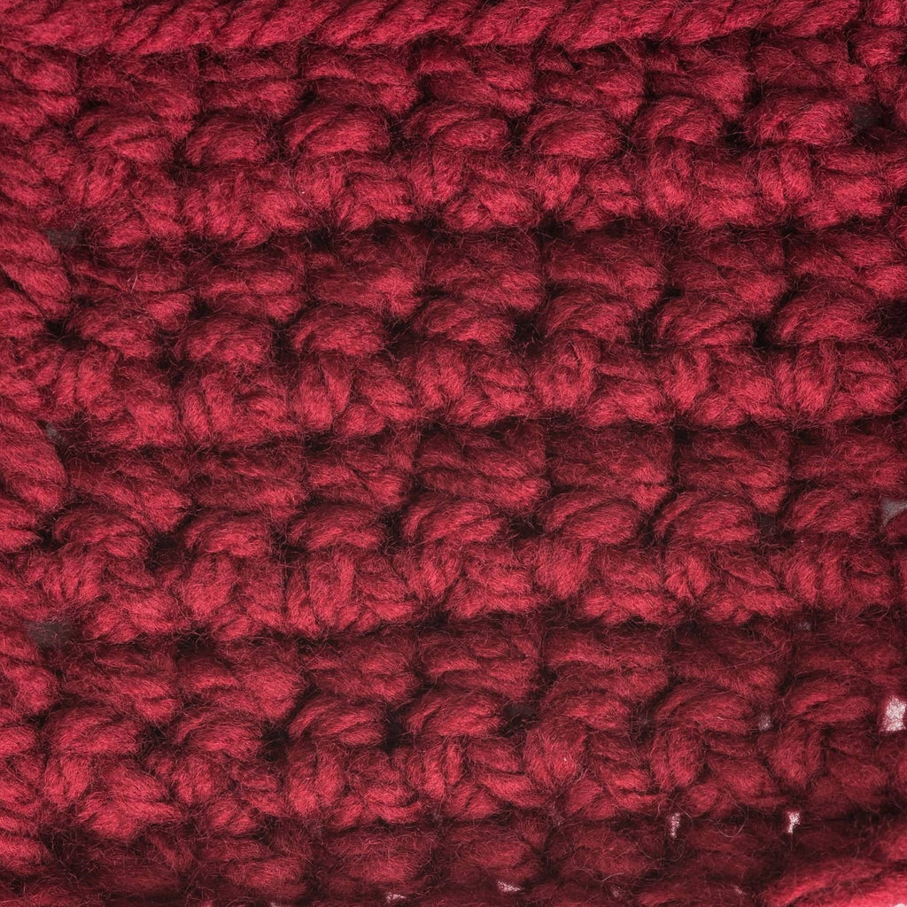 Close-up of deep red chunky acrylic yarn with dense, fluffy twisted texture