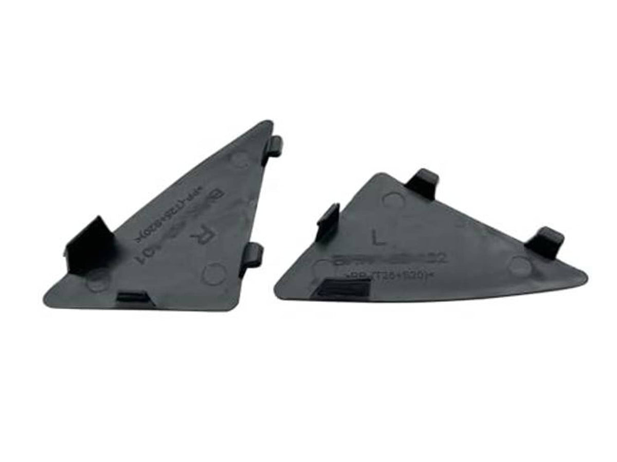 Underside view of two dark triangular grille filler inserts with clip and locator bumps