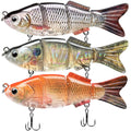 Triple-pack swimbait fishing lures in silver, iridescent, and orange with treble hooks