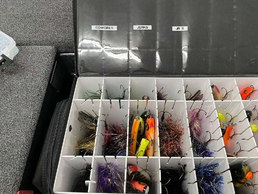 Fishing lure tackle box with rows of colorful lures in open compartments