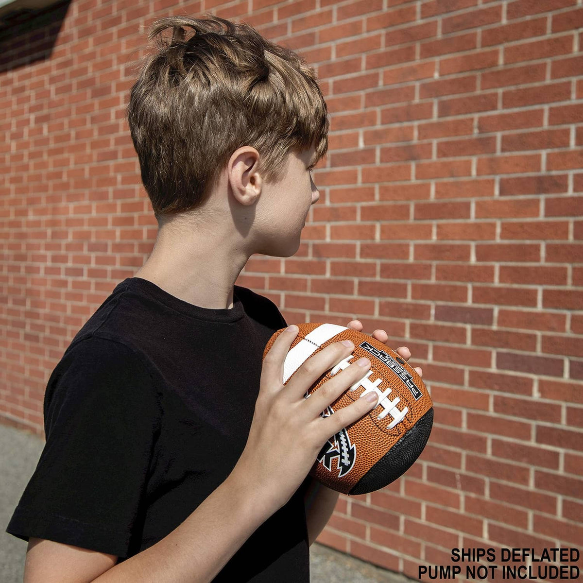 Boy holding an orange youth composite football with white laces and logo