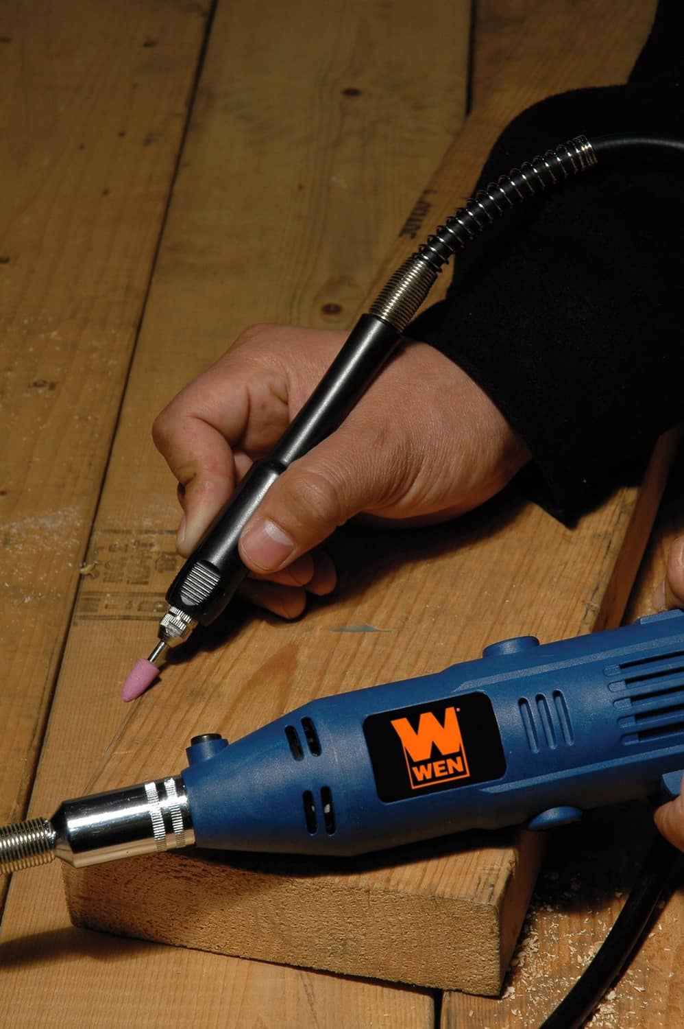 Flex shaft rotary tool in use, sanding wood plank with small attachment