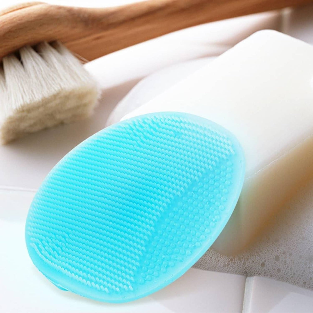 Blue silicone facial cleansing brush with textured bristles on an oval head