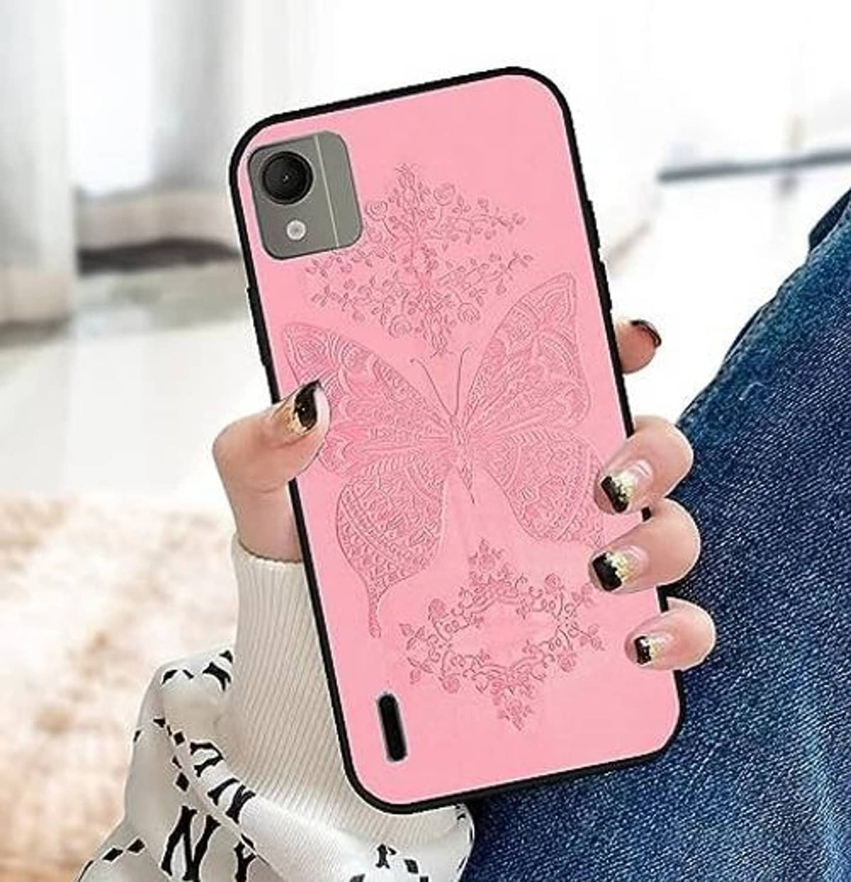 Pink phone case with ornate floral butterfly pattern held in a hand, camera cutouts visible