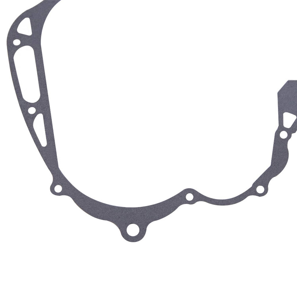 Crankcase cover gasket close-up, dark gray curved shape with mounting holes