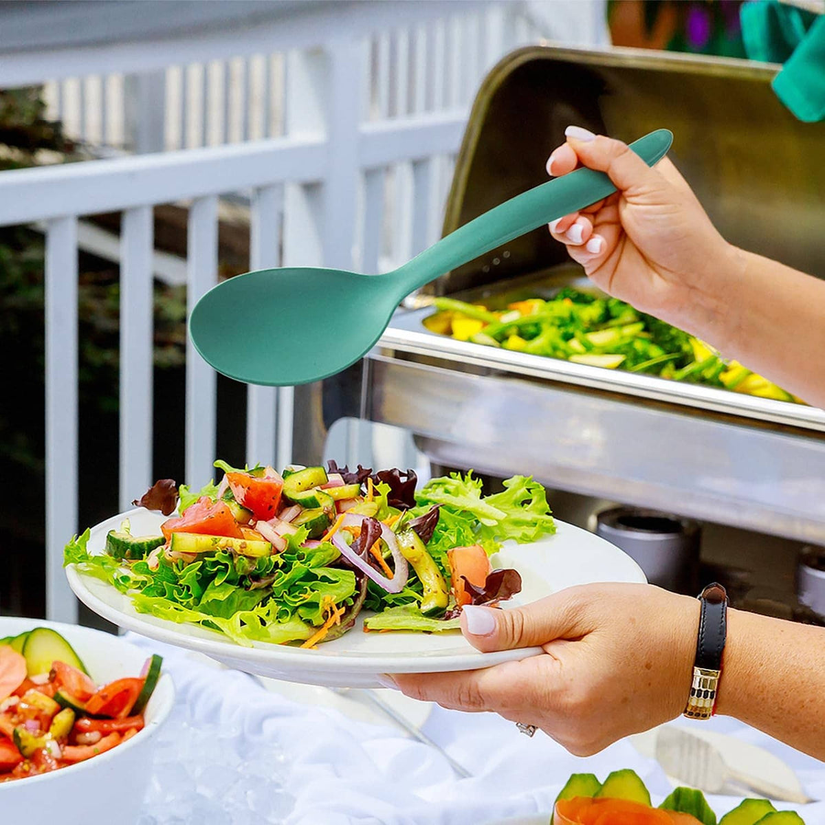 Turquoise large serving spoon scooping salad from a buffet food tray